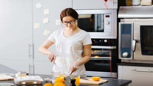 Giovane donna propensa a preparare un dolce in cucina - foto Depositphotos JobsNews.it - StreetFoodNews.it