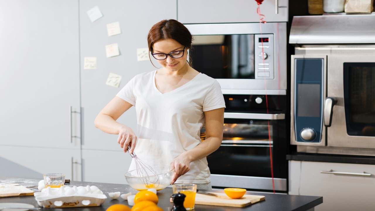 Giovane donna propensa a preparare un dolce in cucina - foto Depositphotos JobsNews.it - StreetFoodNews.it